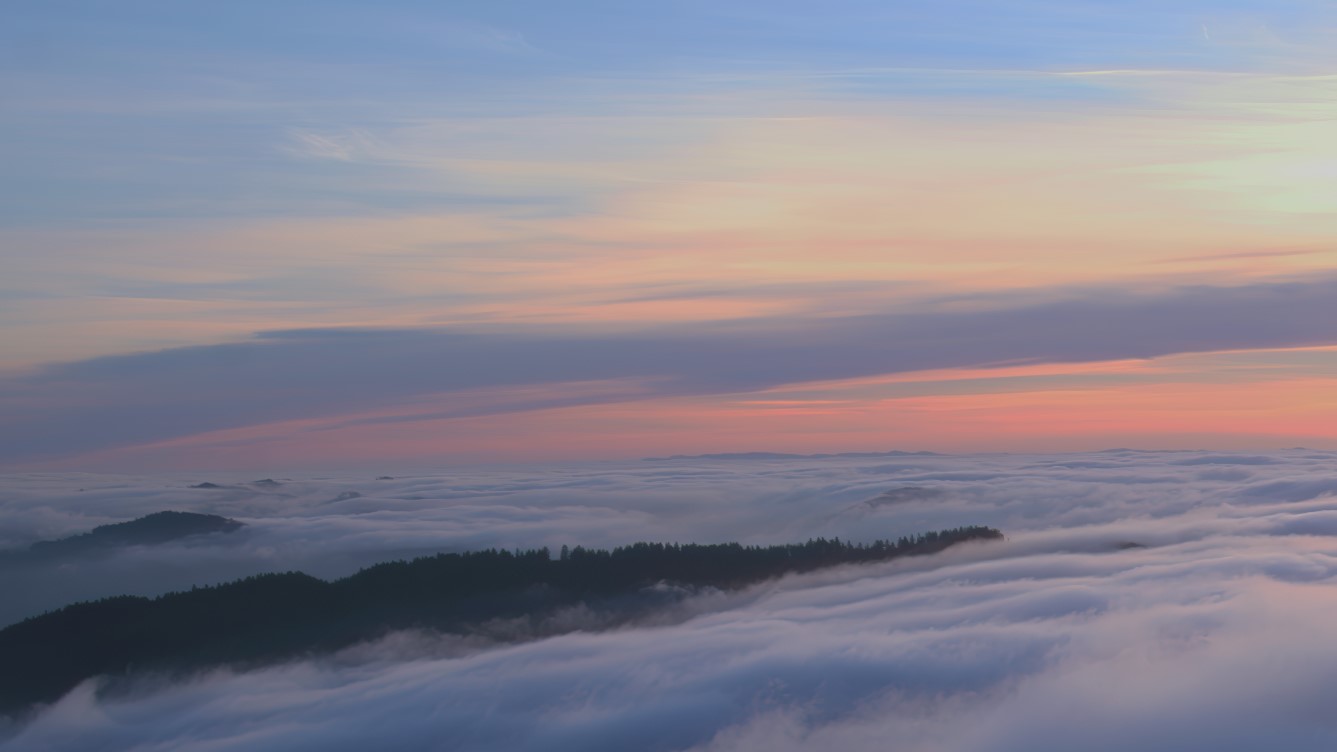 Fog stratus flowing on gentle air currents under some upper-level stratus
