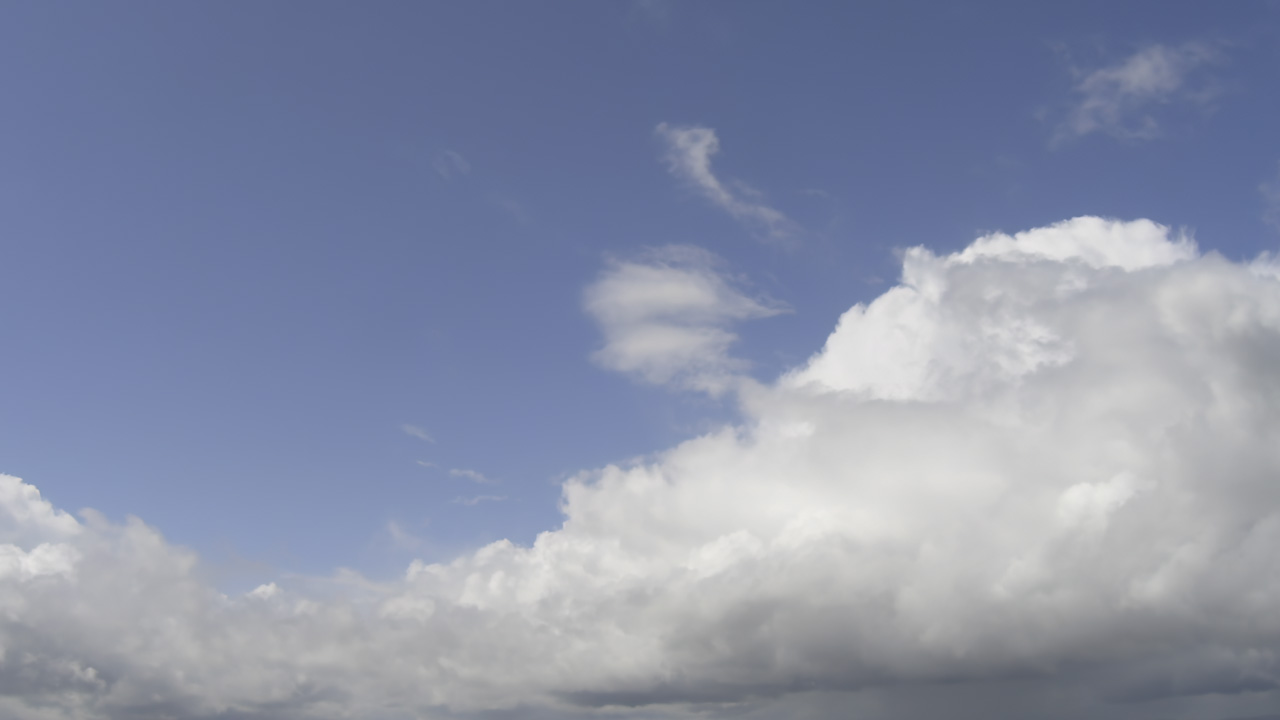 Rain blanket, floating towards in a soft blue sky