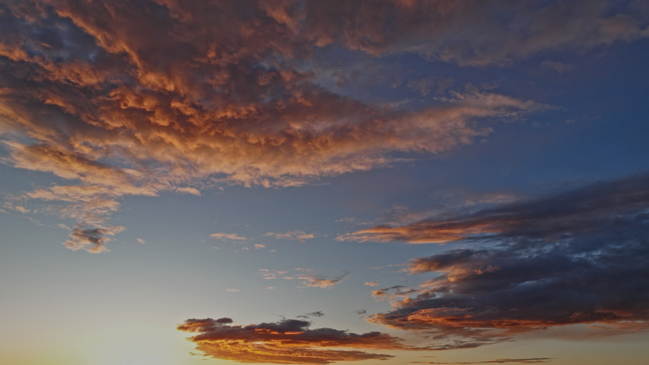 Drone hovering at sunset into dusk, mid-level cloud…