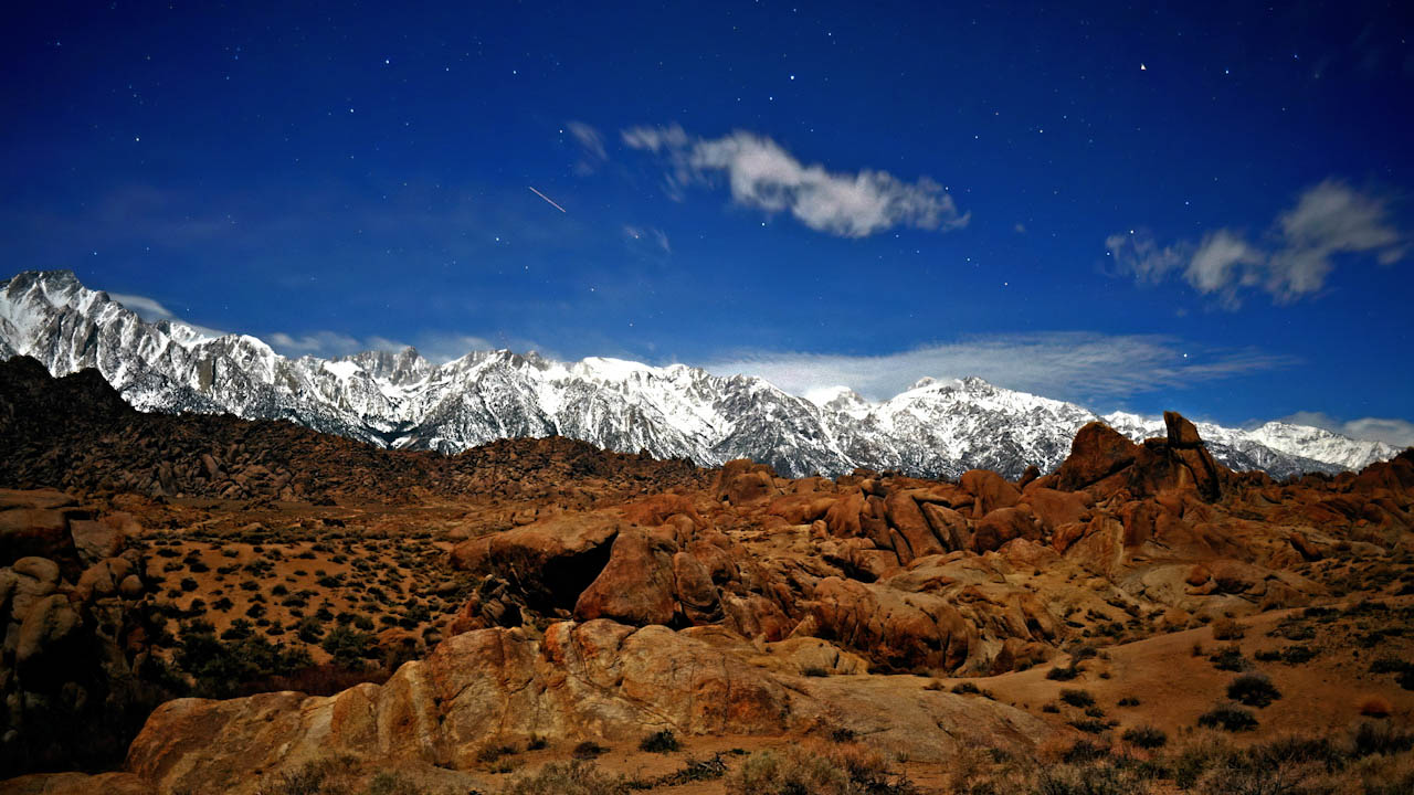 1 of 3 | Low clouds moving at night over mountain range in moonlight