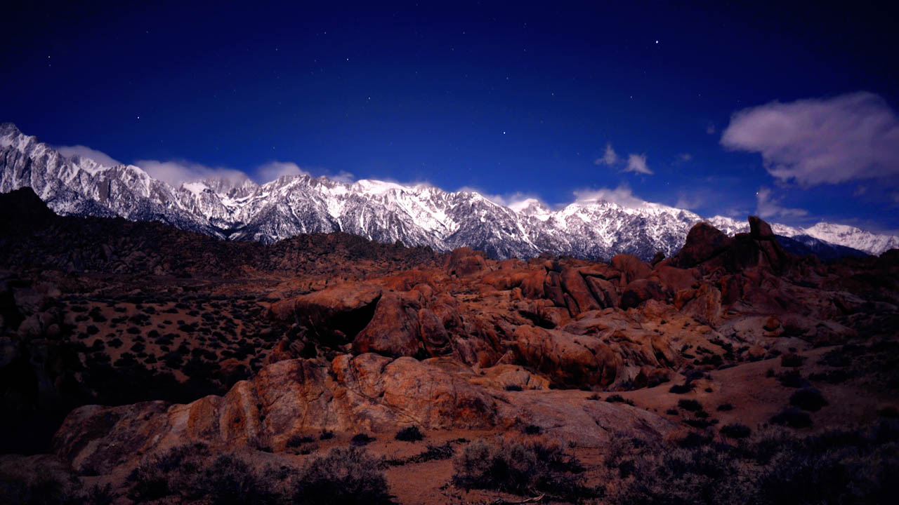 1 of 3 Low clouds moving at night over mountain range in moonlight