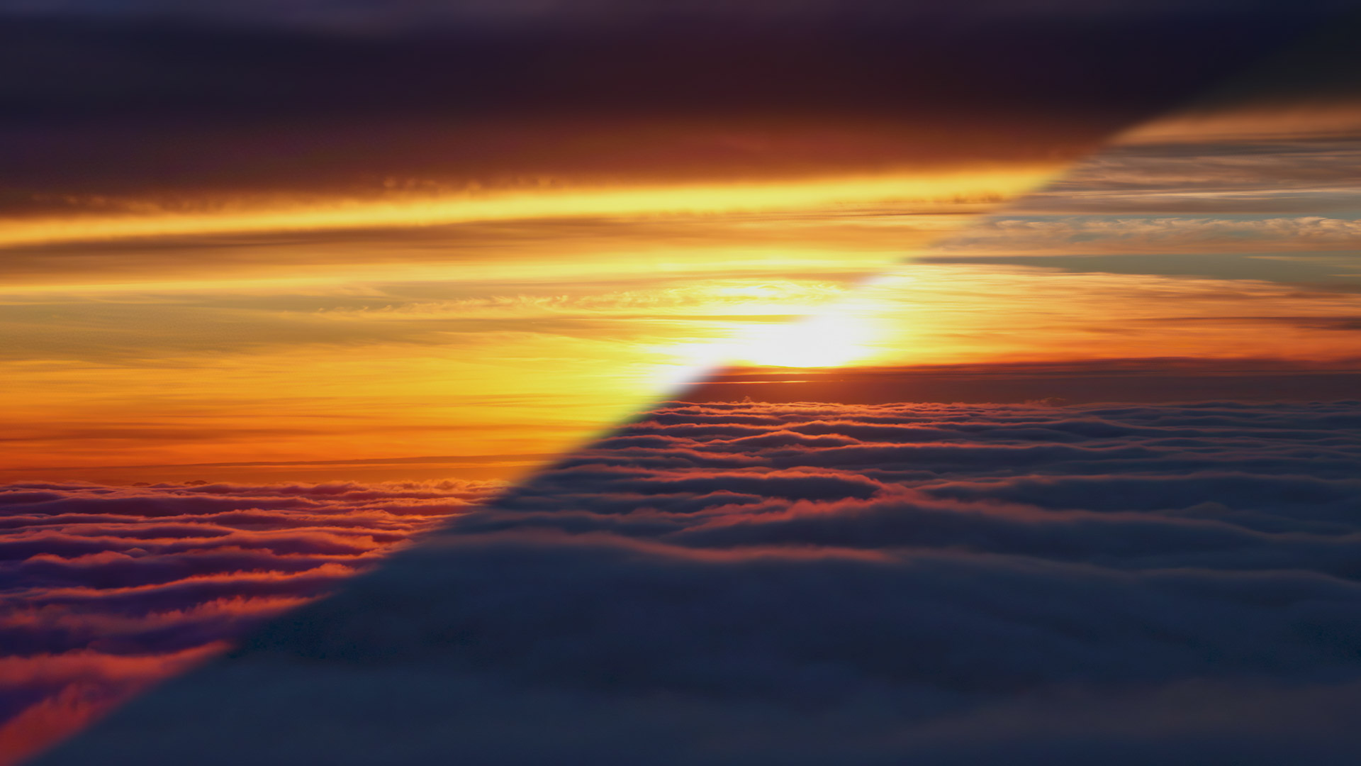 Shapeshifting fog just below with upper-level clouds illuminated at sunset