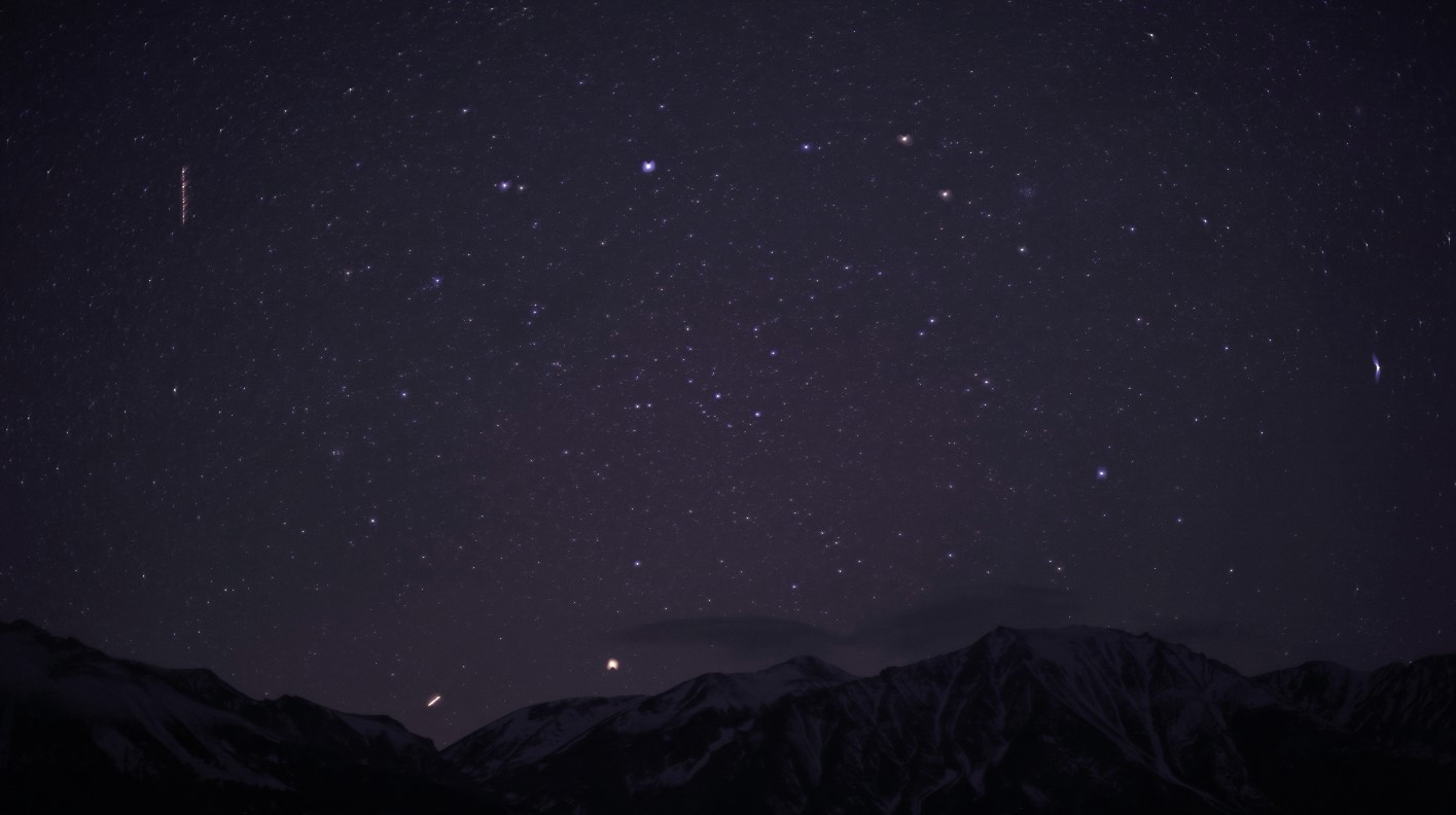 Timelapse of stars over mountain with a thin cap cloud