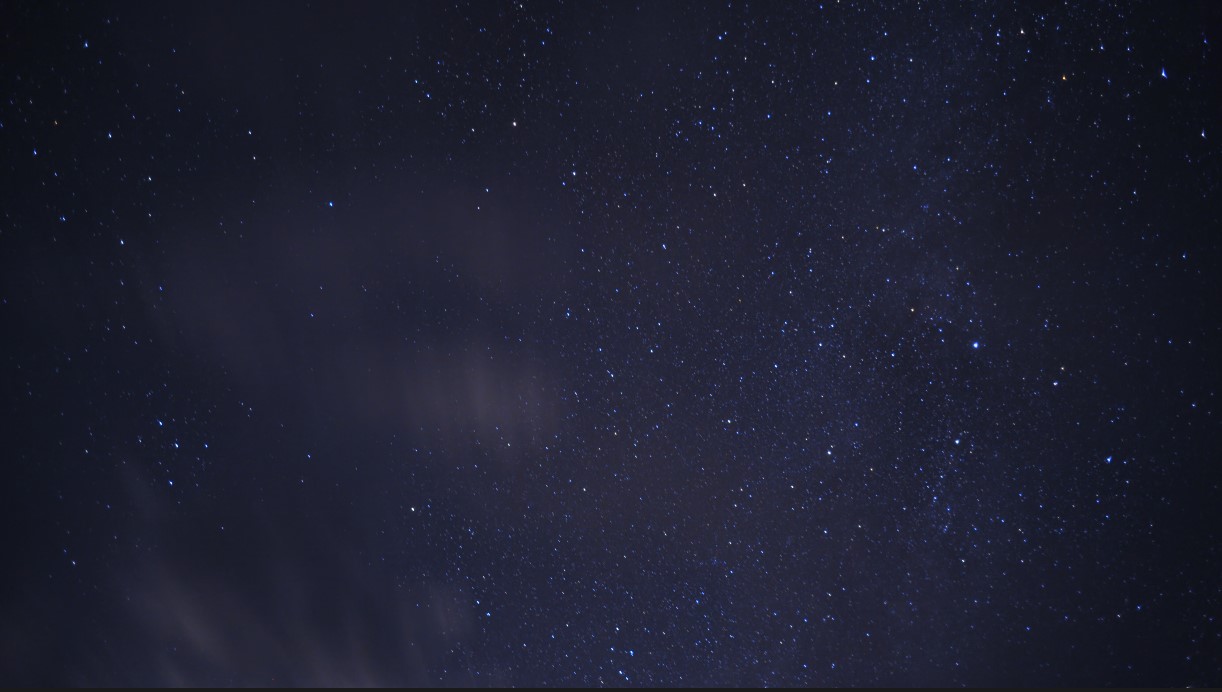 Timelapse of stars with clouds zooming by overhead